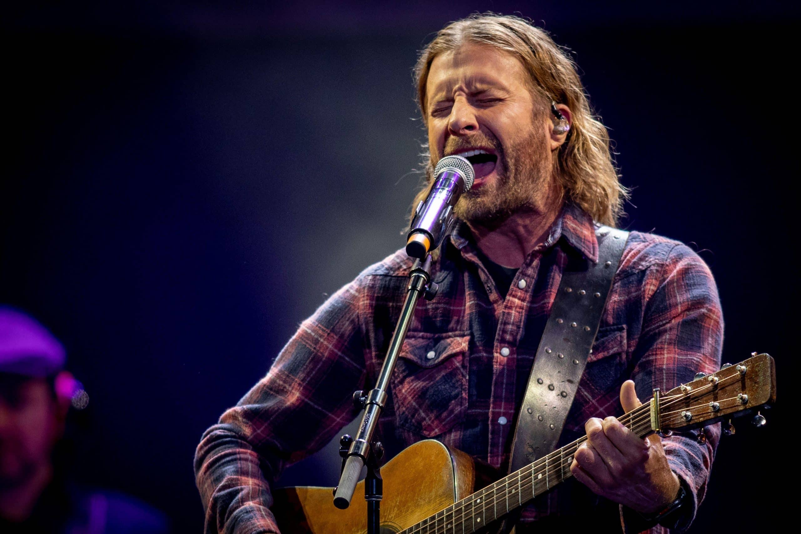 Dierks Bentley singing and playing acoustic guitar on stage