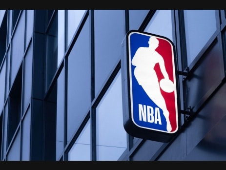 NBA logo sign mounted on the glass facade of an office building