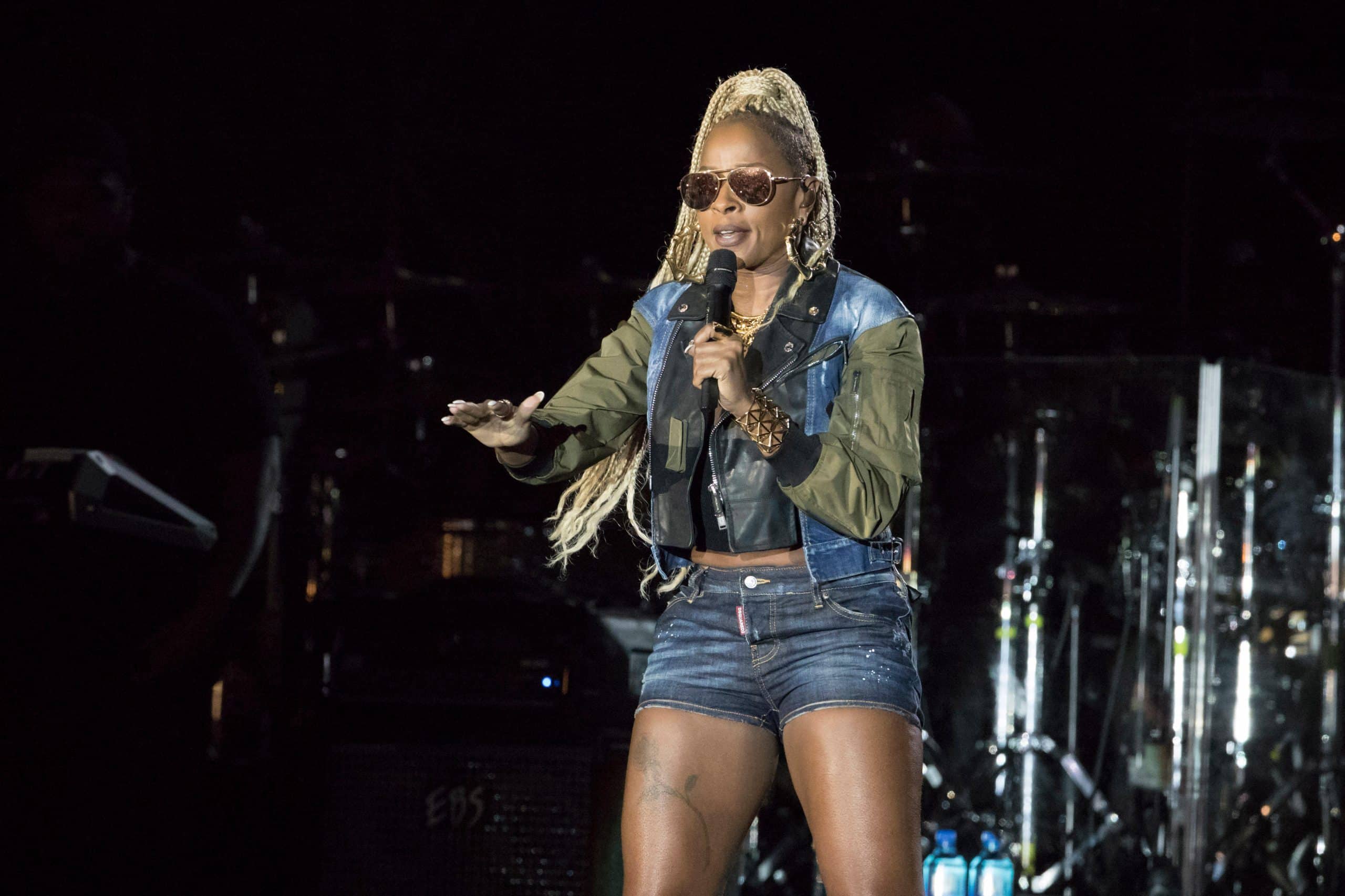 Mary J Blige performing live on stage holding a microphone