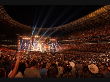 Packed Allegiant Stadium during a country music concert with dramatic stage lighting in Las Vegas