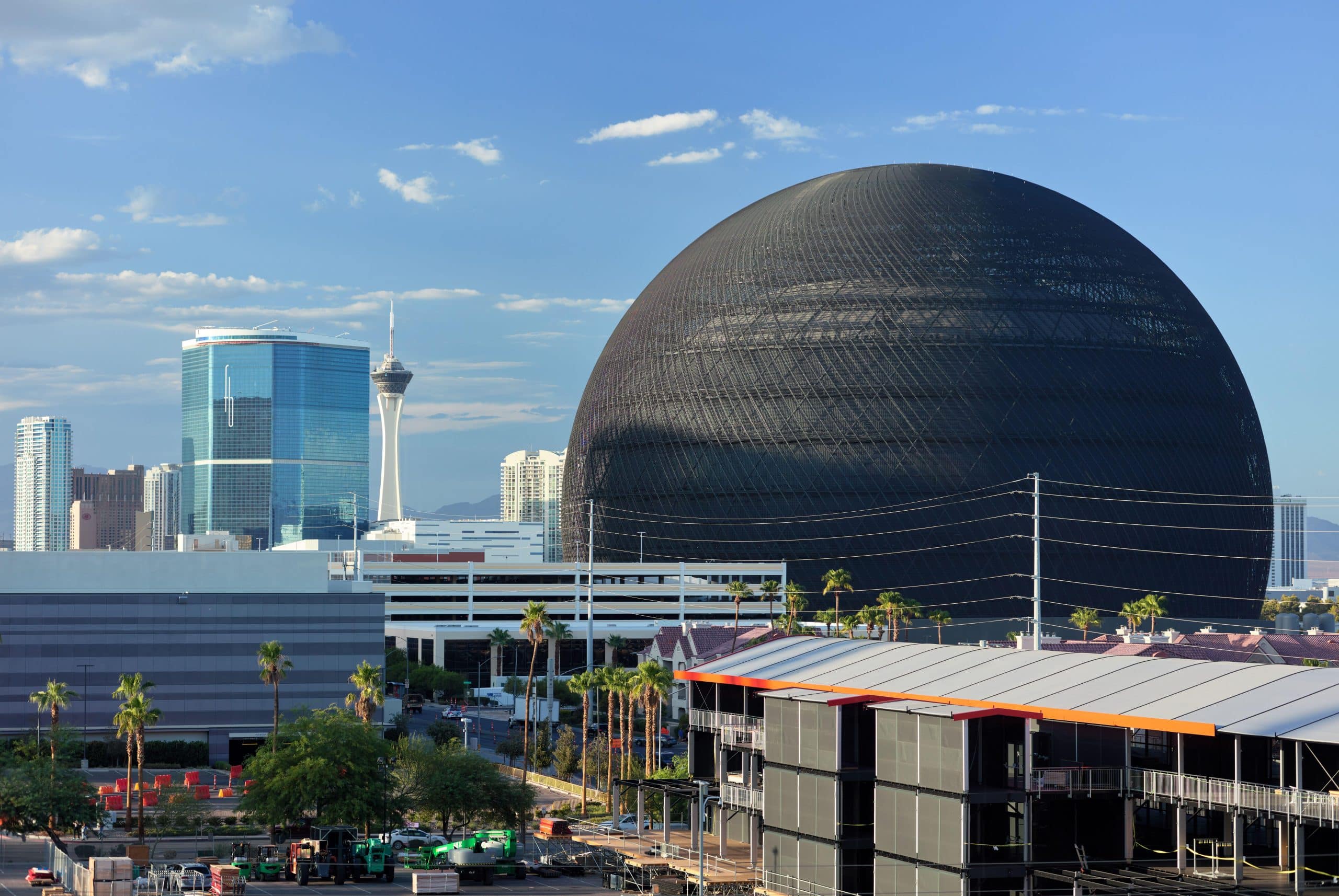 Sphere at Las Vegas in daylight with the Strip skyline, including the Stratosphere Tower, visible behind it